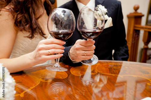 Canvastavla Wedding couple is showing rings while drinking red wine