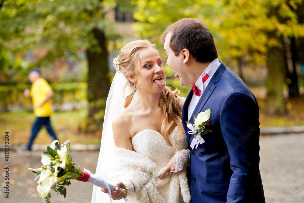 Lovely wedding couple is standing and posing together Lovely wedding couple is standing and posing together