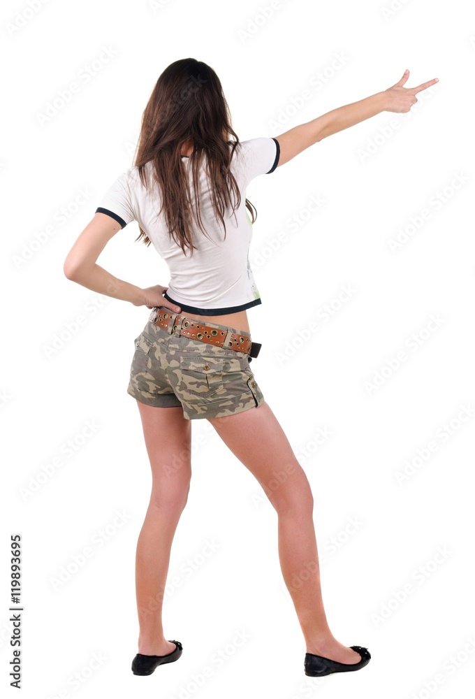 Beautiful young woman in dress pointing at wall. Rear view. Isolated over white. Beautiful young woman in dress pointing at wall. Rear view. Isolated over white.