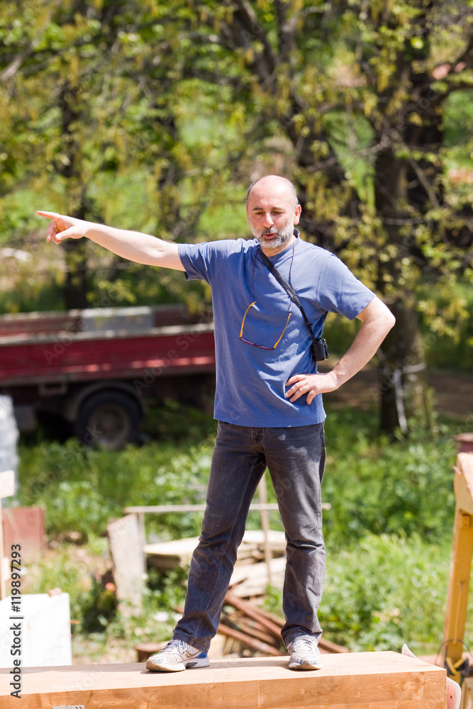Fototapeta premium man on a wooden plank pointing and listening