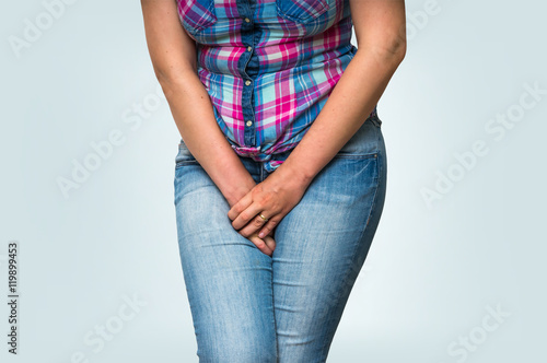 Fototapeta Woman with hands holding her crotch, she wants to pee