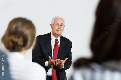 Portrait of Senior Businessman Explaining His Ideas at Conferenc photo