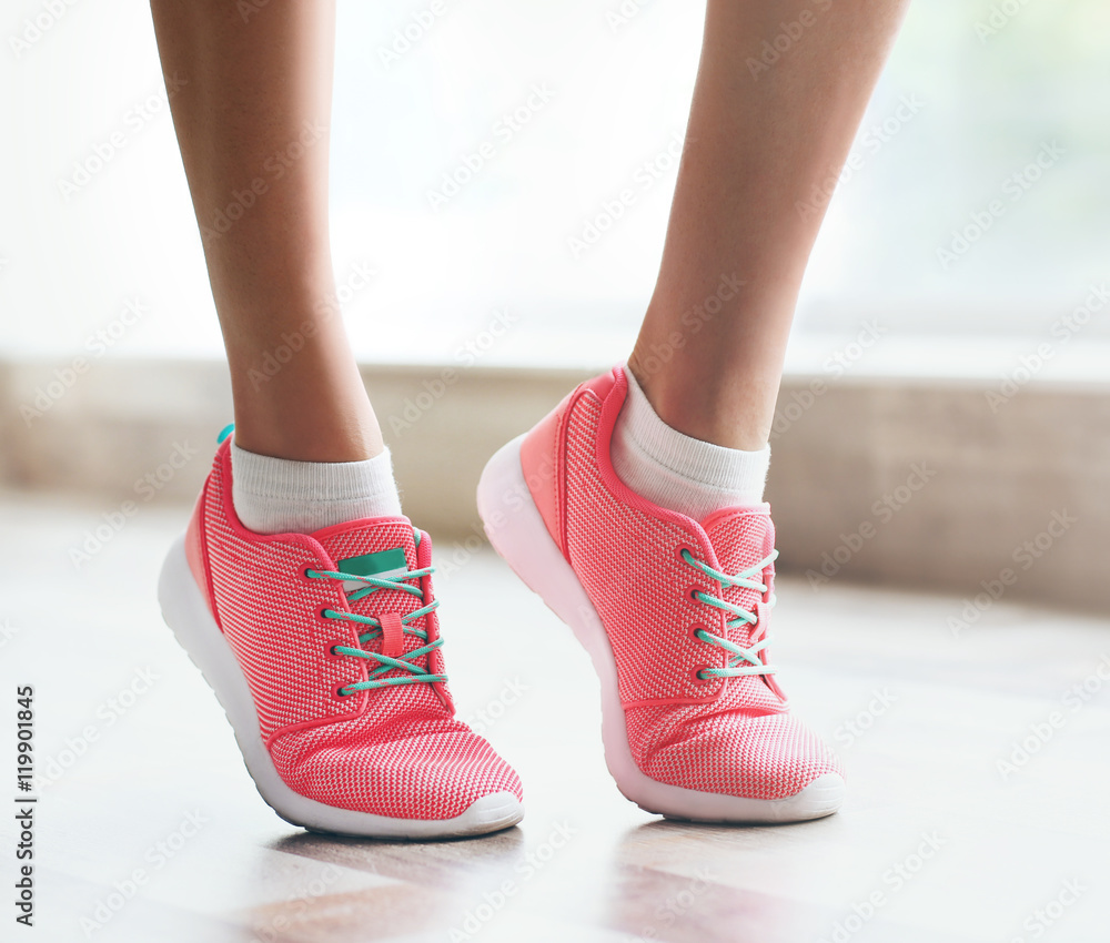 Woman wearing pink sneakers on blurred background