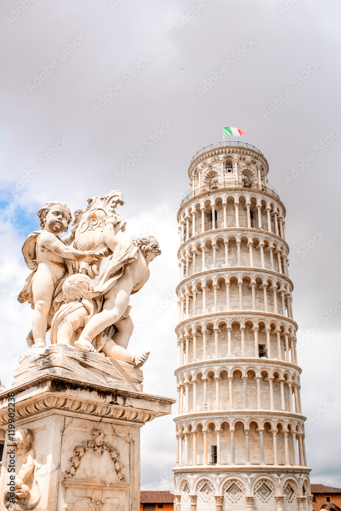Close-up view on Putti fountain with Pisa leaning tower in Italy