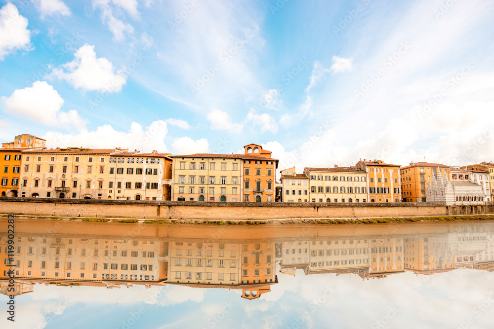 View on the riverside with buildings and palaces with reflection in the water in Pisa town in Italy