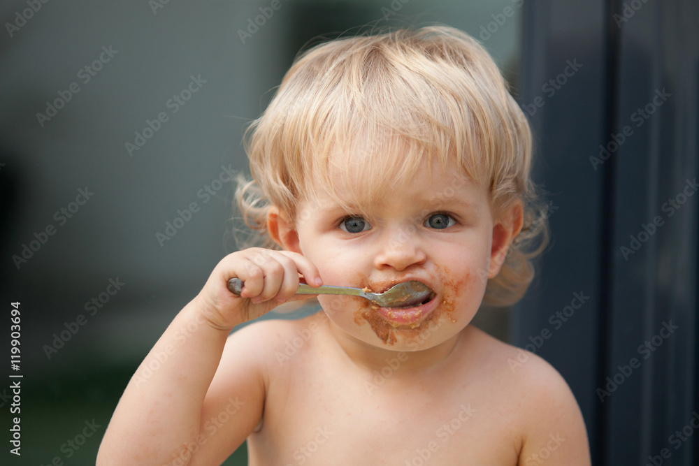 Funny blond baby eating chocolate Funny blond baby eating chocolate