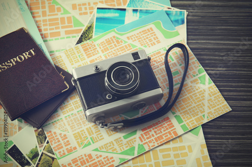 Vintage camera, map and passports on wooden table