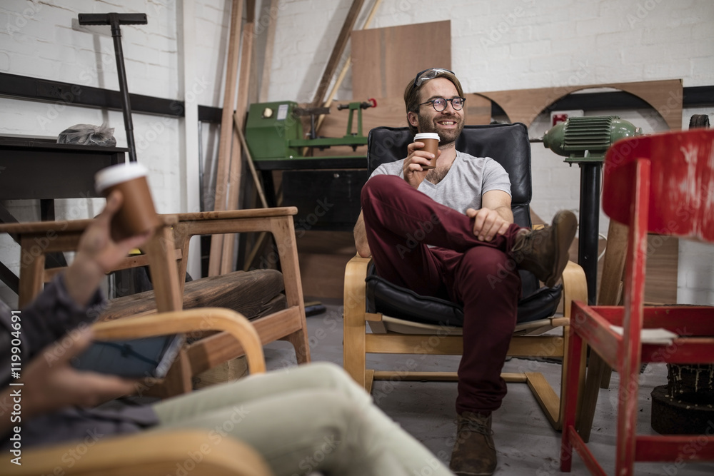 Man drinking coffee in workshop Man drinking coffee in workshop