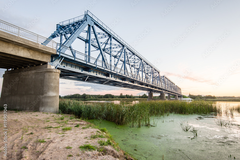 Fototapeta premium railway bridge with metal rails near river