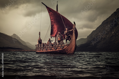 Vikings are floating on the sea on Drakkar with mountains on the