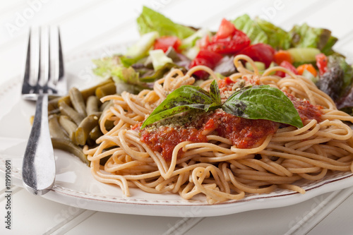 Schilderij op canvas Whole wheat spaghetti topped with organic homemade marinara sauce served with gr