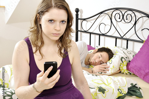 Obraz na plátně Frau schnüffelt heimlich, eifersüchtig und neugierig in Handy oder Smartphone vo