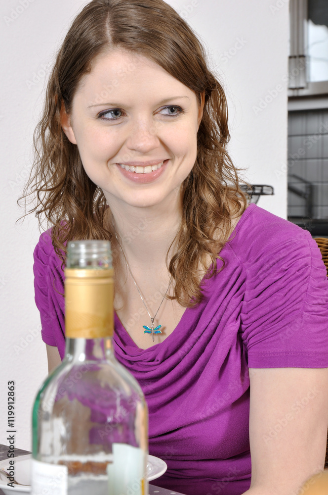 Frau an Tisch von Esszimmer isst Gericht und trinkt Wein