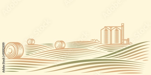 Rural landscape with fields, haystacks and grain elevator