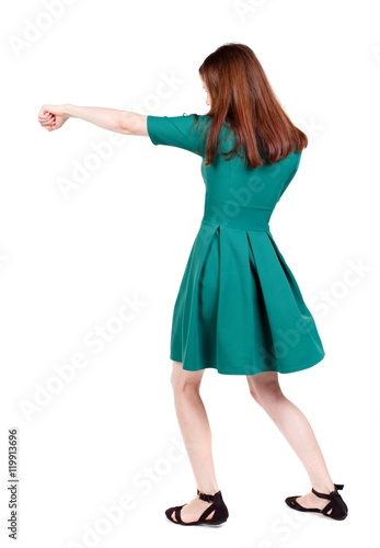 skinny woman funny fights waving his arms and legs. I The slender brunette in a green short dress has outstretched arm. © ghoststone