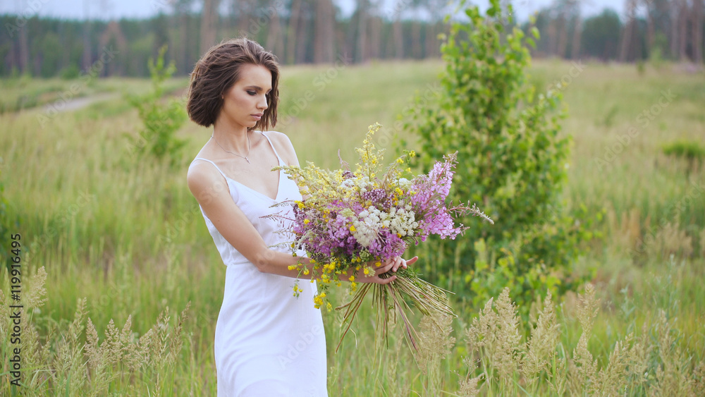 Summer flowering field and a beautiful girl in a white sundress. Summer flowering field and a beautiful girl in a white sundress.