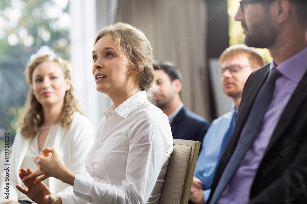 Young businesswoman from audience talking to speaker Young businesswoman from audience talking to speaker