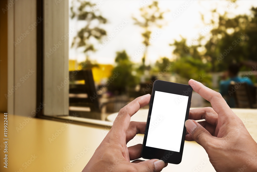 Hand holding smart phone on blurred livingroom Hand holding smart phone on blurred livingroom