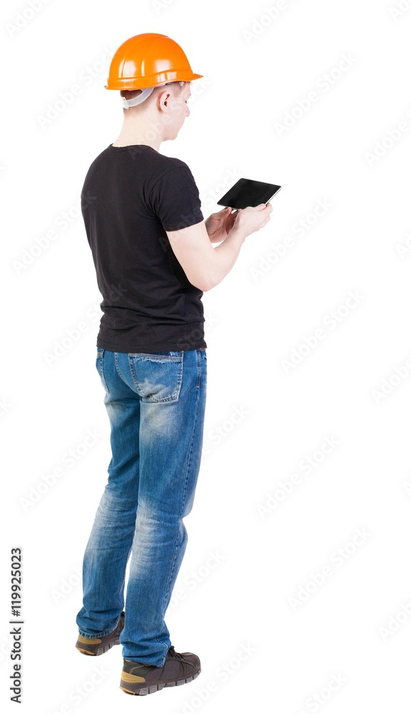 young engineer in a protective helmet with tablet computer in the hands of. girl watching. Rear view people collection. backside view of person. Isolated over white background. young engineer in a protective helmet with tablet computer in the hands of. girl watching. Rear view people collection. backside view of person. Isolated over white background.