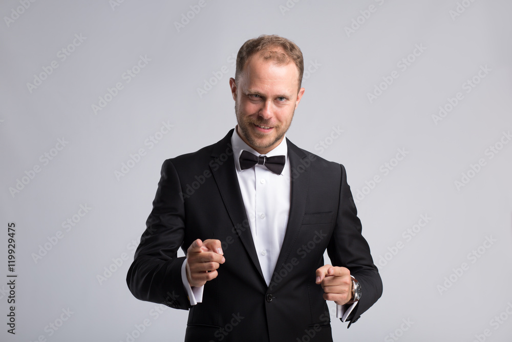 Handsome businessman in classic suit make confirmation gesture on gray background Handsome businessman in classic suit make confirmation gesture on gray background