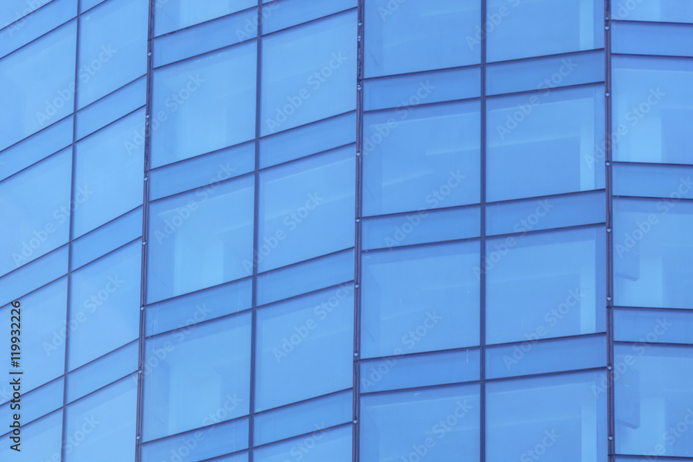 The glass facade of a skyscraper with a mirror reflection of sky windows The glass facade of a skyscraper with a mirror reflection of sky windows