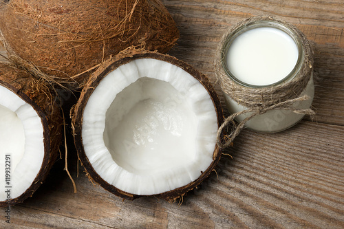 Exotic coconuts, coconut butter and milk on wooden background. Organic healthy food concept. Beauty and SPA concept.