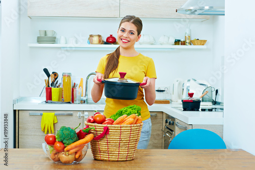 Beautiful woman cooking healthy food in home kitchen.