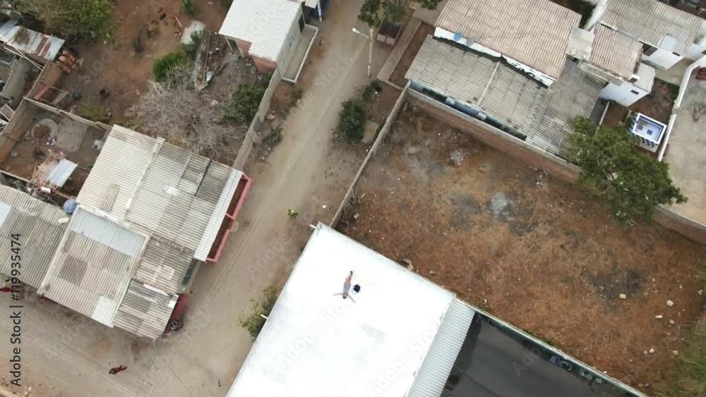 Aerial shot of woman relaxing on rooftop in a poor neighborhood of Colombia 4k Aerial shot of woman relaxing on rooftop in a poor neighborhood of Colombia 4k