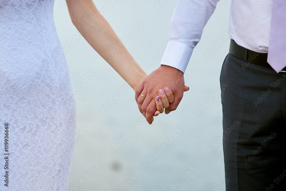 Wedding photo of bride and groom holding hands