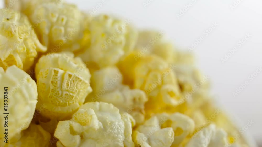 Salt popcorn in box on white background, rotation, very close up Salt popcorn in box on white background, rotation, very close up