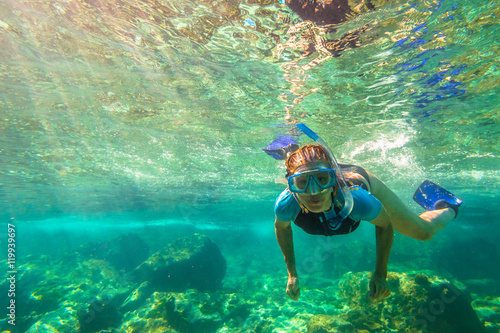Close up of female apnea swims in tropical turquoise sea of Racha Noi, Phuket in Thailand.