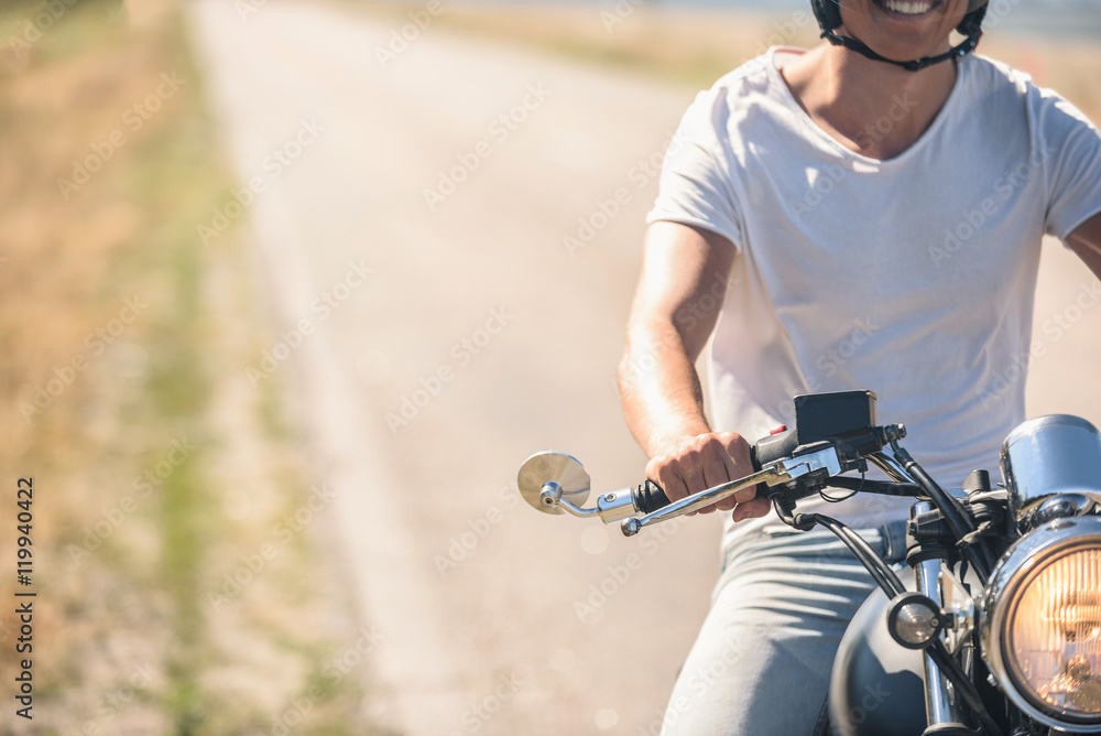 Young man riding his motorbike on open road Young man riding his motorbike on open road