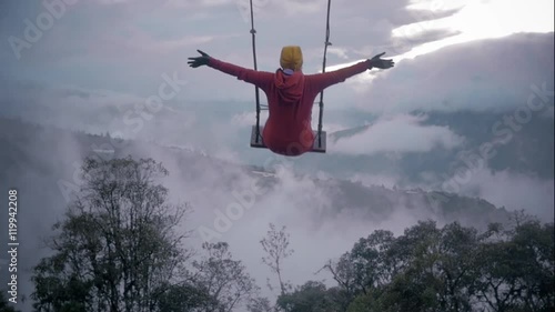 Woman in a swing over the mountains