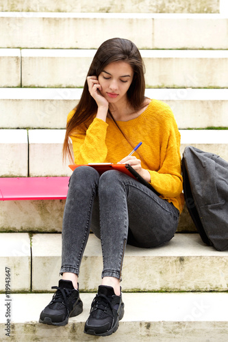 Attractive student sitting on steps thinking © mimagephotos