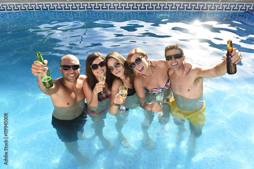 Canvas Print happy attractive men and women in bikini having bath at hotel resort swimming po