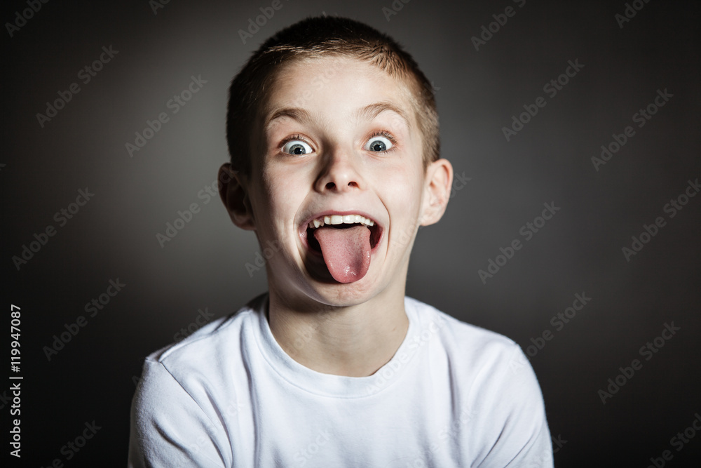 Goofy male child making faces in darkened room Goofy male child making faces in darkened room