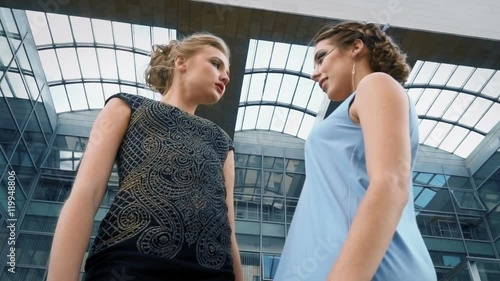 The girl posing together at camera on background of business building photo