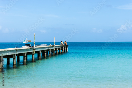 Fototapeta Naklejka Na Ścianę i Meble -  Boardwalk into the tropical sea with blue sky