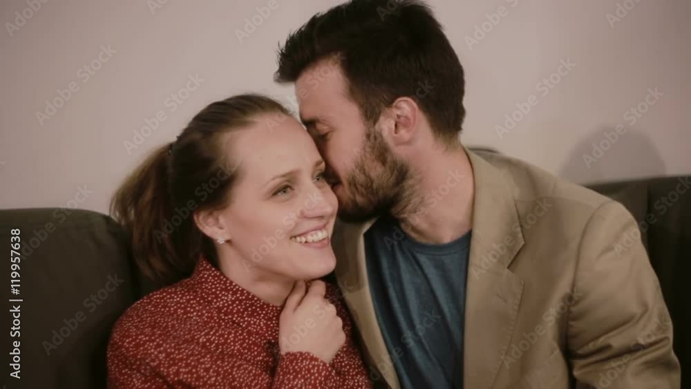 A man and a woman smiling and talking. A man is whispering something into a woman ear. A man and a woman smiling and talking. A man is whispering something into a woman ear.