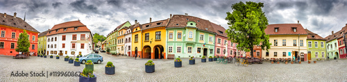 Panorama of the Sighisoara Citadel Square or Fortress Square. Colourful medieval houses with dramatic skies. Panoramic montage from 11 HDR images photo