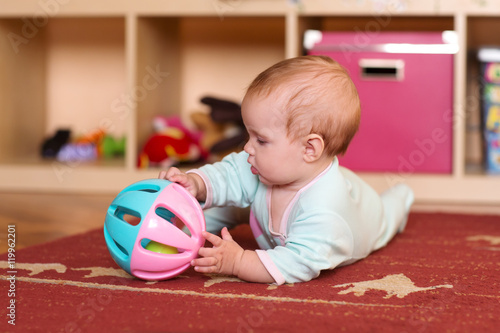 Baby playing and crawling, making faces,  on the floor.

