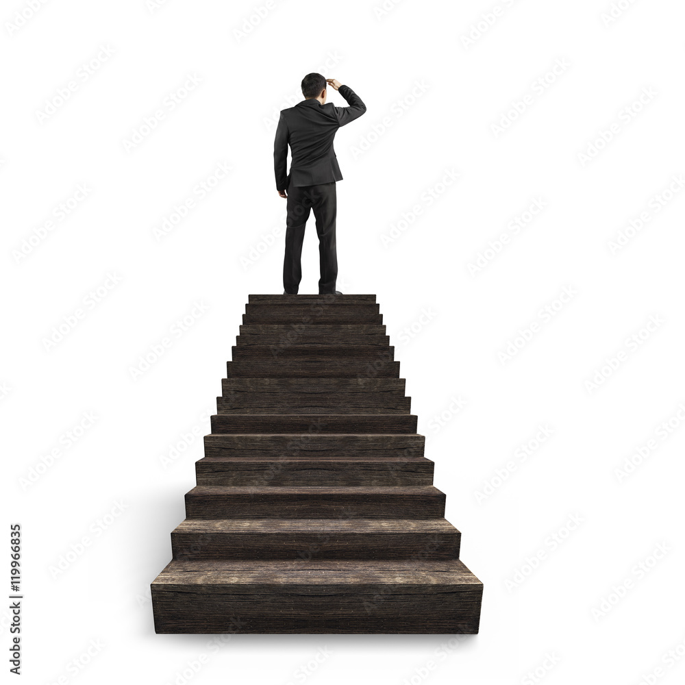 Businessman gazing on top of wooden stairs