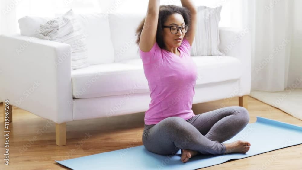 happy african woman exercising on mat at home happy african woman exercising on mat at home