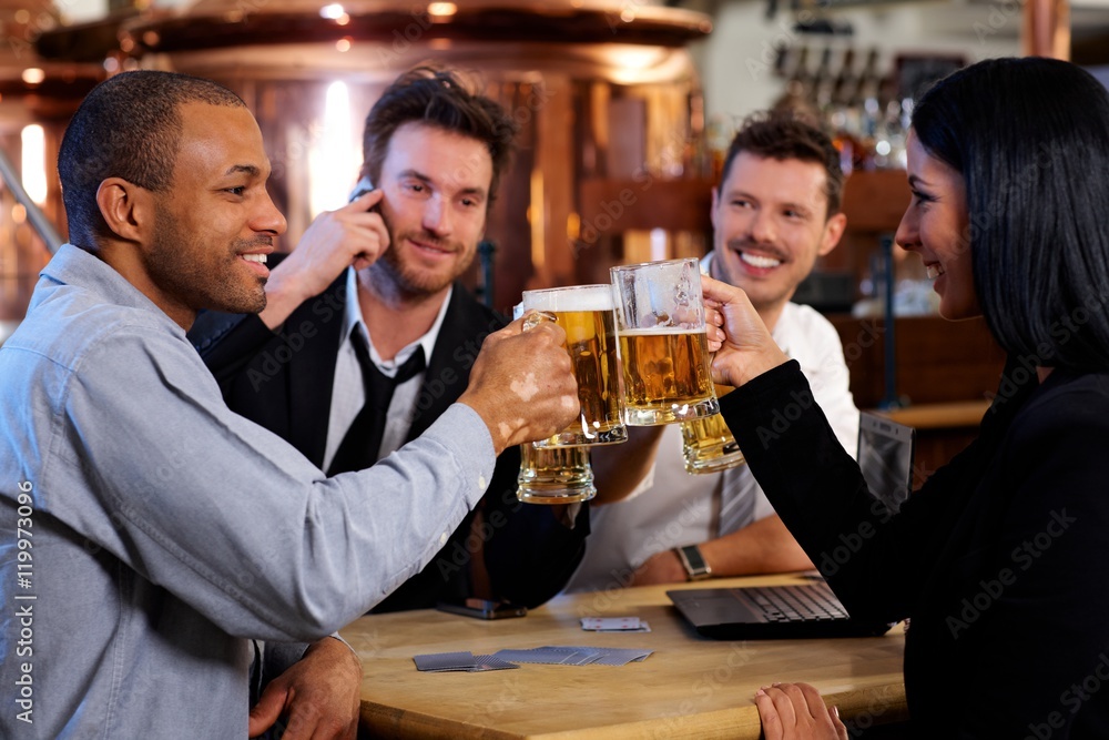 Young office workers toasting with beer at pub Young office workers toasting with beer at pub