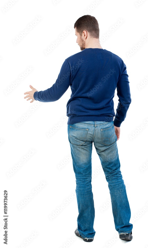 back view of businessman reaches out to shake hands. bearded man in blue pullover extends his hand in greeting. back view of businessman reaches out to shake hands. bearded man in blue pullover extends his hand in greeting.