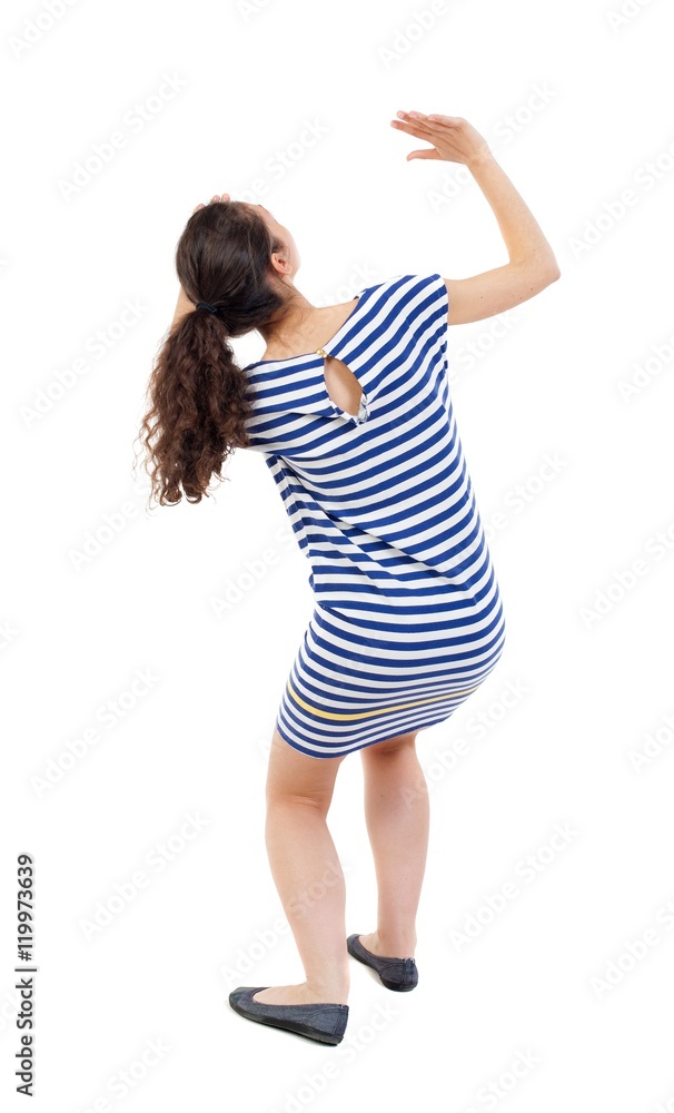 Fotka „back view of woman protects hands from what is falling from above.  Swarthy girl in a checkered dress frightened of something on top.“ ze  služby Stock | Adobe Stock