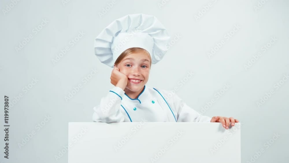 Chef 7-8 years behind the whiteboard waving hand and looking at camera. Isolated on white Chef 7-8 years behind the whiteboard waving hand and looking at camera. Isolated on white