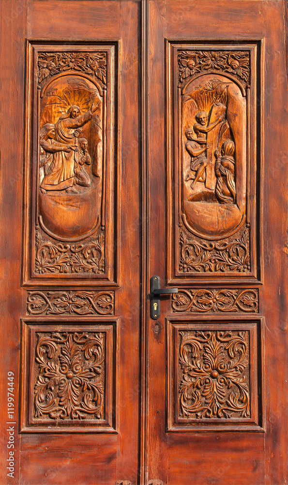 carved wooden door with Biblical figures in the old church in Eu