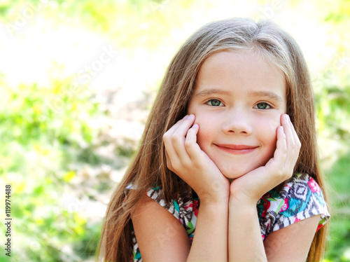 Portrait of adorable smiling little girl in summer day