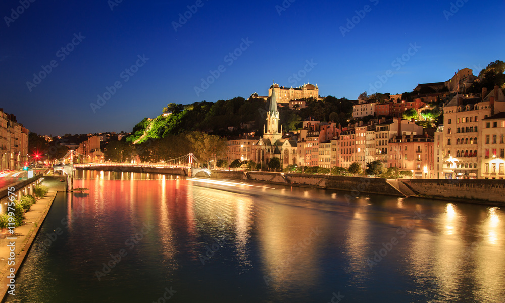Night view over the Saone river to Passerelle Saint Georges in Lyon, France.